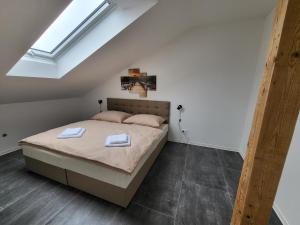 a bedroom with a bed with two towels on it at Apartmány Vulcano in Perná