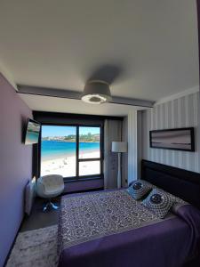 a bedroom with a bed and a view of the beach at Luxury centro Silgar in Sanxenxo