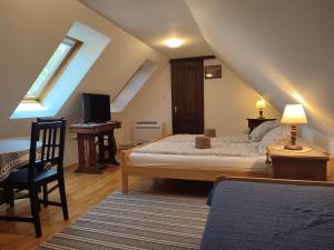 a bedroom with a bed and a desk with a computer at Szent Iván Vendégház in Tata