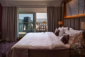 a bedroom with a large white bed with a balcony at Bank Hotel, a Member of Small Luxury Hotels in Stockholm