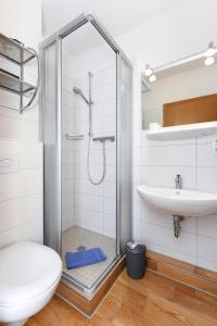 a bathroom with a shower and a toilet and a sink at Hotel-Pension Störtebeker in Bensersiel +59 photos