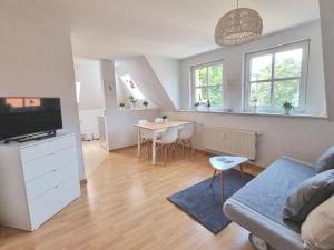 a living room with a couch and a tv and a table at 2 room apt at It-district Neustadt & free parking in Dresden