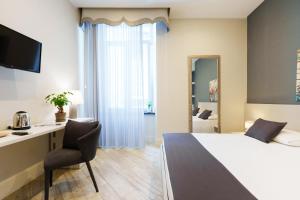a hotel room with a bed and a desk and a chair at It’s Room in Naples