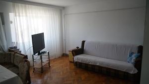 a living room with a couch and a flat screen tv at Apart Portul Turistic in Mangalia