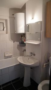 a bathroom with a sink and a toilet and a tub at Apart Portul Turistic in Mangalia