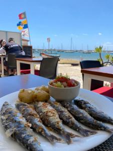 einen Teller Sardinen und eine Schüssel Salsa in der Unterkunft Prainhaactivitiesbeachhouse in Alvor