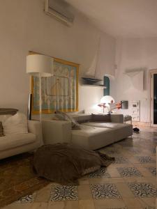 ein Wohnzimmer mit einem Sofa und einem Kissen auf dem Boden in der Unterkunft Prainhaactivitiesbeachhouse in Alvor