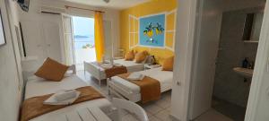 una camera d'albergo con due letti e un bagno di Amaranthos Skiathos View a Megali Ammos