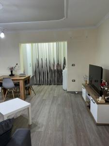 a living room with a couch and a table and a television at Amaras Apartment in Tirana