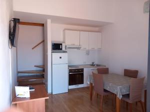 a small kitchen and dining room with a table and chairs at Orchid in Selce