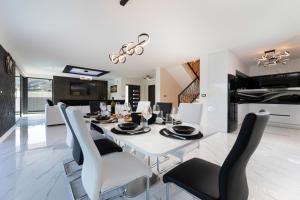 a dining room and kitchen with a white table and chairs at Villa Bellezza in Draga Bašćanska