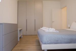 a white bedroom with a bed and a dresser at Ca' Martha - A due passi dal centro con parcheggio privato - Aeroporto 2 chilometri in Treviso