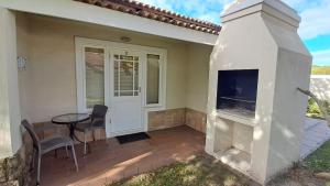 eine Terrasse mit einem Kamin vor einem Haus in der Unterkunft Studio 37 @ The Dunes in Plettenberg Bay