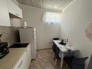 a small kitchen with a table and a small refrigerator at Apartmani Luciano in Novalja