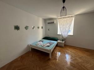 a room with a bed in the corner of a room at Apartmani Luciano in Novalja