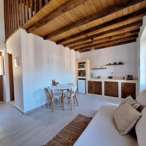 a kitchen and living room with a table and chairs at To Pefko - Mezzanines - in Meyisti