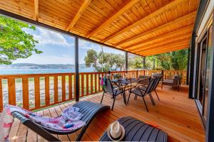 a wooden deck with a table and chairs on it at Mobile Homes Camp Perna - Adriatic Kampovi in Orebić