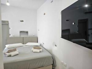 a white room with a bed with towels on it at Aristotelis Homes in Katapola