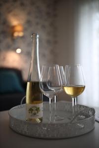a bottle of wine and two wine glasses on a tray at Angele Pihenőház in Balatonszárszó +69 photos