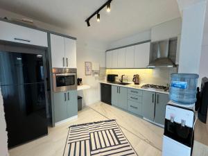 a kitchen with white cabinets and a black refrigerator at AQUA Suite Kemer in Kemer
