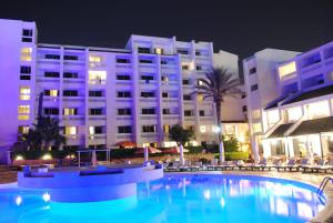 uma piscina em frente a um hotel à noite em HAMILTON Agadir em Agadir