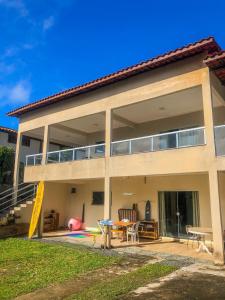a large house with a patio and a table at Surf Stop Hostel Serra Grande in Uruçuca