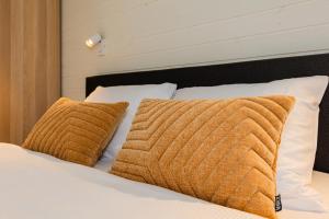 a bed with two brown pillows on it at Resort 23 in Želviai