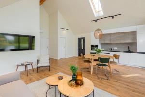 a living room with tables and chairs and a kitchen at Resort 23 in Želviai +24 photos