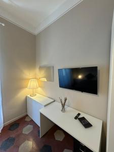 ローマにあるVaticano Roma Guesthouseの白いデスク、壁掛けテレビが備わる客室です。