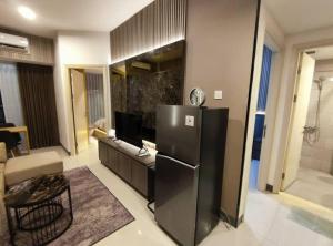 a kitchen with a black refrigerator in a room at Apartment Benson Tower 2 Bed Room by Lavida in Surabaya