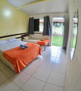 グアイビムにあるBimba Chalés - Guabim - BAのベッドルーム1室(オレンジ色の毛布付きのベッド1台付)