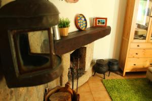 a fireplace in a living room with a stone mantle at Casa do Rio - Eido do Pomar in Arcos de Valdevez