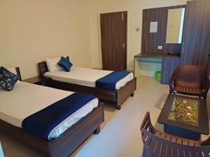 a bedroom with two beds and a desk and a chair at The Urban Escape in Guwahati