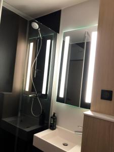 a bathroom with a shower and a sink and mirrors at ibis Laon in Laon