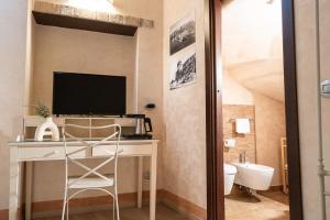 a bathroom with a desk with a television and a toilet at La Lisca in Termoli