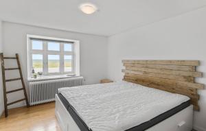 a white bedroom with a bed and a window at Lovely Home In Løgstør With Wifi in Løgstør +8 photos