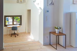 un couloir avec une table, une chaise et une fenêtre dans l'établissement Eismöwe, à Barth