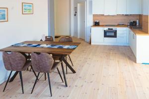 une cuisine avec une table en bois et quelques chaises dans l'établissement Eismöwe, à Barth 10 autres photos