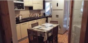 a kitchen with a table and chairs in a room at Eforie Brio in Eforie Nord