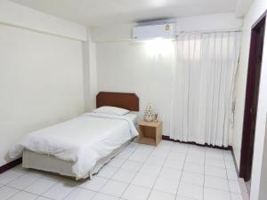 een witte slaapkamer met een bed en een raam bij Baan Sathorn 21 in Yan Nawa +4 foto's