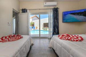 2 camas en una habitación con vistas a la piscina en Swiss Paradise Aruba Luxury Collection, en Palm-Eagle Beach 110 fotos más