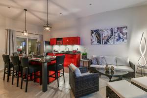 Una cocina y sala de estar con gabinetes rojos y una mesa. en Swiss Paradise Aruba Luxury Collection, en Palm-Eagle Beach