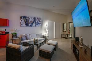 Una sala de estar con un sofá y un televisor de pantalla plana. en Swiss Paradise Aruba Luxury Collection, en Palm-Eagle Beach