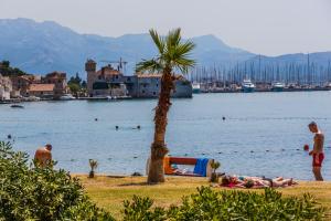 un grupo de personas yaciendo en la playa cerca del agua en Moonlight Luxury Apartment, en Kaštela