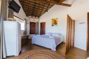a bedroom with a bed and a flat screen tv at Casa de Sal - Barra Grande (Piscina, lounge e churrasqueira) in Barra Grande +42 photos