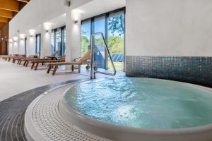 a jacuzzi tub in a building with chairs at Ośrodek Wypoczynkowy Łańsk in Stawiguda