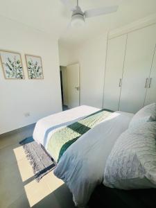 two beds in a bedroom with white walls at Ballito Village Suites in Ballito +13 photos