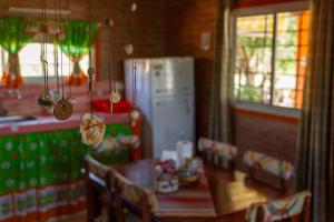 a kitchen with a refrigerator and a table and chairs at Complejo Utopia-Chacras de la Primavera, Tanti in Tanti