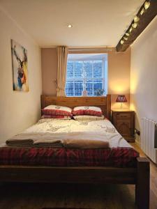 a bedroom with a large bed with a window at Private Woody Apartment, 2 King Beds, Very Centre Stamford in Lincolnshire