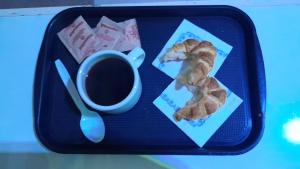 a tray with a cup of coffee and a cookie at Hotel Litoral CERCA DE MOVISTAR ARENA in Buenos Aires